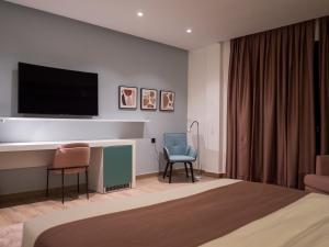 努瓦克肖特HOTEL HIBA的酒店客房带一张床、一台电视和椅子