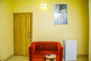 拉各斯ONTARIO SUITES的一间设有红色椅子和冰箱的客房