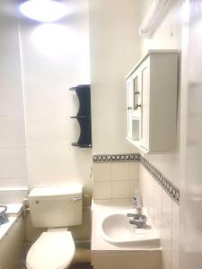 伦敦Large self-contained cozy studio的浴室配有白色卫生间和盥洗盆。