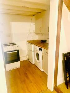 伦敦Large self-contained cozy studio的厨房配有炉灶和洗衣机。