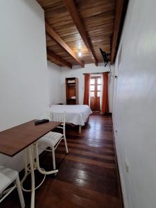 卡哈马卡Casa Wayra Cajamarca的一间设有两张床和一张桌子及椅子的房间