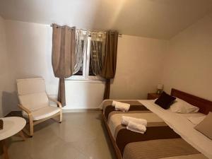 萨利Apartments by the sea Sali, Dugi otok - 8110的一间卧室设有两张床、一把椅子和一个窗户。