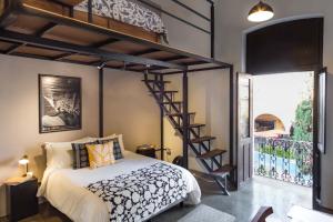 AcámbaroCasa Ibarra的一间卧室设有高架床和螺旋楼梯。