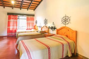 乌鲁阿潘Hotel Pie de la Sierra的一间卧室,配有三张床