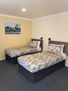 凯库拉海湾汽车旅馆的一间卧室设有两张床,墙上挂着一幅画