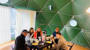 SoraySky Lodge Domes Salkantay的一群坐在餐桌旁吃饭的人