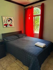 圣萨尔瓦多MonBlanc的一间卧室配有床和红色窗帘的窗户