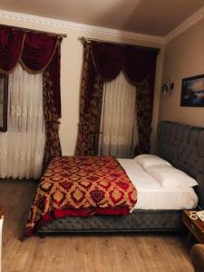 伊斯坦布尔BeyPort Hotel Taksim的一间卧室配有一张带红色毯子和窗帘的床