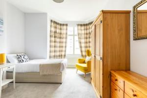 达灵顿Paradise House Darlington的一间卧室配有一张床和一张黄色椅子