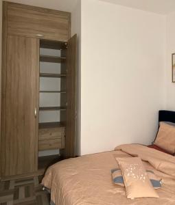 布拉柴维尔SYN - Corniche的一间卧室配有一张床和一个木制橱柜