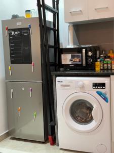 布拉柴维尔SYN - Corniche的厨房配有洗衣机和冰箱。
