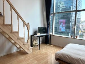 首尔Hongdae Station loft apartment的一间卧室设有楼梯,书桌配有电脑