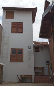 圣若昂-达巴拉Mini Casa Furnas - Capitólio MG的白色的房子,设有木门和长凳