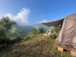 河江Nậm Lỳ Retreat- Breakfast included的两人坐在山顶的帐篷里
