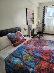 圣地亚哥Hotel Gigi的一间卧室配有一张带彩色毯子的床
