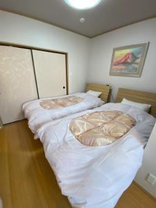 京都东寺君子之家公寓的配有白色床单的客房内的两张床