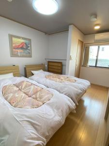 京都东寺君子之家公寓的带窗户的客房内的2张白色床