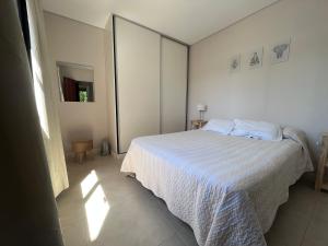 罗萨里奥Depto acogedor, moderno y espacioso的卧室配有白色的床和镜子