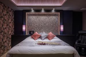 横滨ホテル シードット 横浜 トレ的卧室配有一张带粉红色枕头的大床