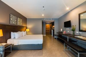 芭堤雅市中心西米泉酒店的配有一张床和一张书桌的酒店客房