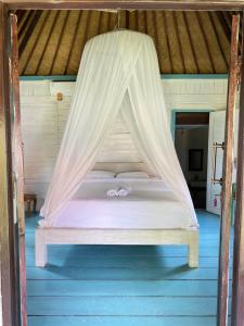 MungguKubu Di Omo Villas的配有蚊帐的客房内的一张床位