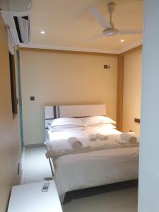 马累Fanfini Residence Male’的一间卧室配有一张带白色床单和天花板的床。