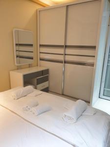 马累Fanfini Residence Male’的卧室配有一张带镜子的白色床