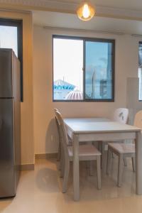 马累Fanfini Residence Male’的厨房配有桌椅和窗户。