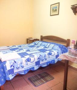 VallegrandeHostal Juanita的一间卧室配有一张带蓝色和白色被子的床
