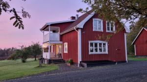 AnebyLantligt hus på Knohult的红色的房子,设有白色的窗户和门廊