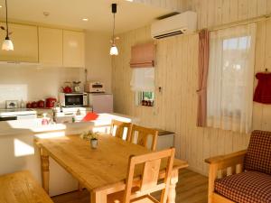 轻井泽Tree Village Karuizawa的厨房以及带木桌的用餐室。