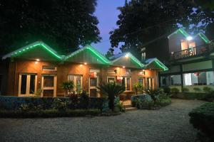 拉塔古里Akarshan Bono Bunglow的夜晚有绿灯的房子