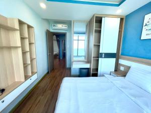 芽庄Mường Thanh Luxury Viễn Triều Apartment的卧室配有白色的床和蓝色的墙壁