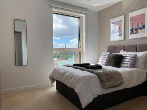 伦敦7th floor apartment的一间卧室设有一张大床和大窗户