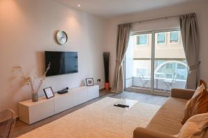 迪拜Deluxe 1 Bedroom Apartment - Elite Residence Dubai Marina - Sea View的客厅设有壁挂式平面电视。