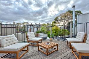 悉尼3 Bedrooms - Darling Harbour - Darghan Street 2 E-Bikes Included的露台配有椅子和桌子,甲板上配有桌子
