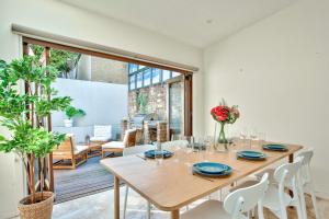 悉尼3 Bedrooms - Darling Harbour - Ada Place的一间带木桌和椅子的用餐室