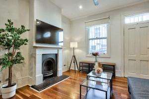 悉尼3 Bedrooms - Darling Harbour - Ada Place的客厅设有壁炉和桌子