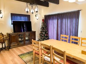 轻井泽Tree Village Karuizawa的一间设有桌子和圣诞树的用餐室