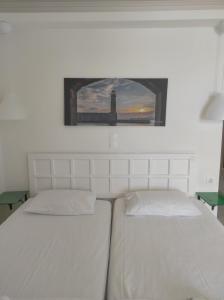 罗希姆诺菲罗夏聂海滩酒店的一间卧室配有两张床,享有灯塔的景色