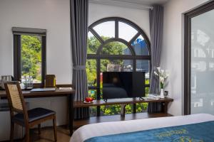 吉婆岛CatBa Green Pearl Hotel的一间卧室设有一张桌子和一个大窗户