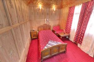 斯利那加New kolohai group of houseboats的一间卧室配有红色的床和红色窗帘