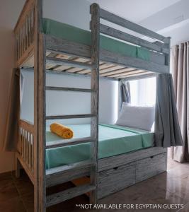达哈布Tranquilo Boutique Hostel - Dahab的带梯子的客房内的双层床