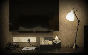 怡保1969 Business Suites的一张桌子,上面有台灯,墙上有一台电视
