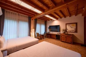 全州市Jeonju Wangyijimil Hanok Hotel的一间卧室配有两张床和一台平面电视