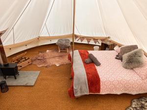 FoulshamThe Queens Head Glamping的帐篷内一间卧室,配有一张床