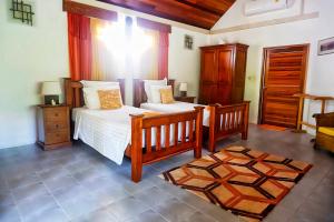 奈扬海滩金斯吉尔酒店的一间卧室配有两张单人床和一张地毯。