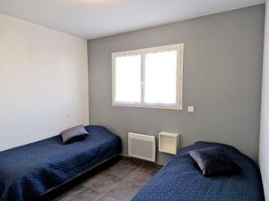 勒宝洛Le Brasil - Maison 74 m - Calme avec terrasse Sud classée 3 étoiles的一间卧室设有两张床和窗户。