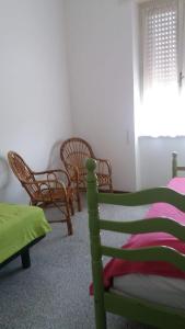 蓬泰圣乔瓦尼APPARTAMENTO GYNKgO的一间卧室配有床、椅子和窗户