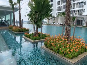 班吉SY@Tiara Homestay的一座种植了鲜花和棕榈树的游泳池
